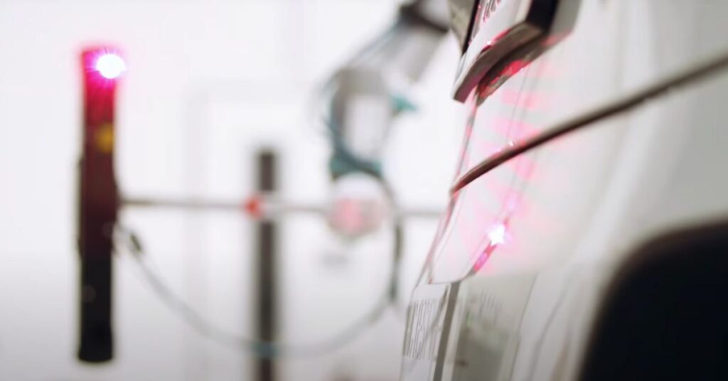 MotionCam-3D casting a parallel structured light pattern on the inspected car. 