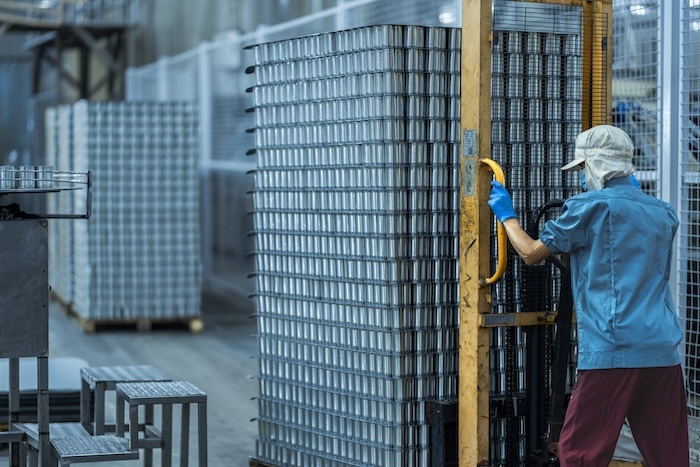 worker-operating-a-pallet-jack-to-move-stacked-can-2025-06-29-16-51-44-utc